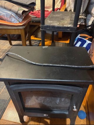 Estufa de leña negra con puerta de cristal