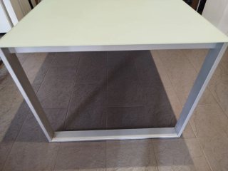 Taula metàl.lica amb sobre de vidre glaçat.