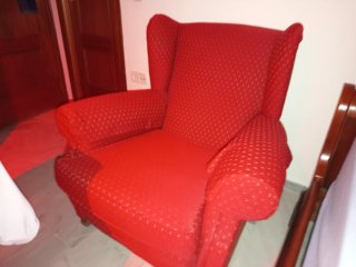 Sillón orejero rojo con reposabrazos
