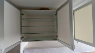 Muebles de cocina blancos, con puertas de cristal.