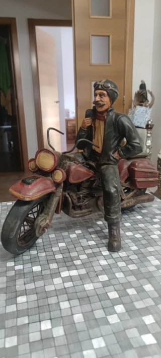 Figura de motorista en moto clásica