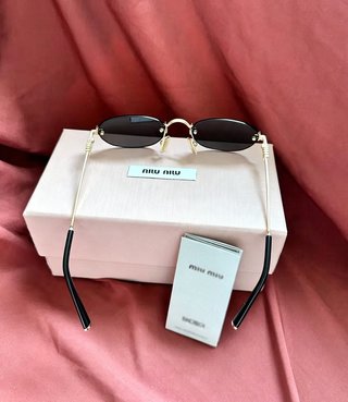 Gafas de sol Miu Miu negras y doradas