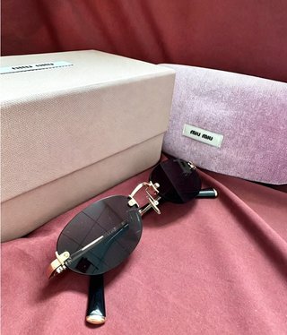 Gafas de sol Miu Miu negras y doradas