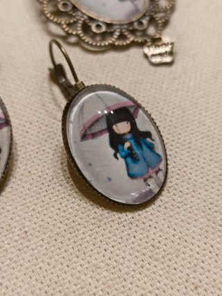 Broche y pendientes con niña bajo paraguas