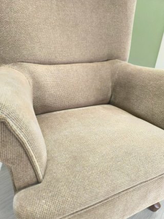 Sillón de tela beige con cojín amarillo