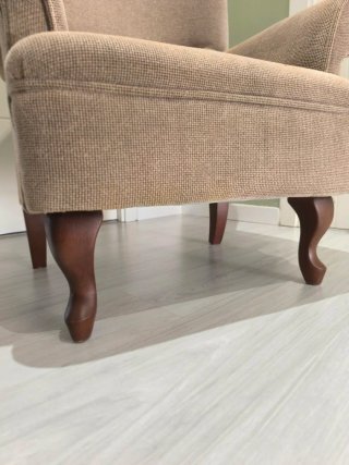Sillón de tela beige con cojín amarillo
