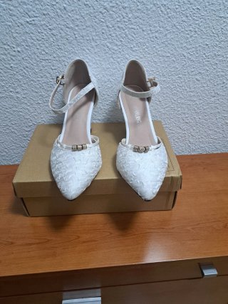 Zapatos de tacón blancos roto con pedrería .