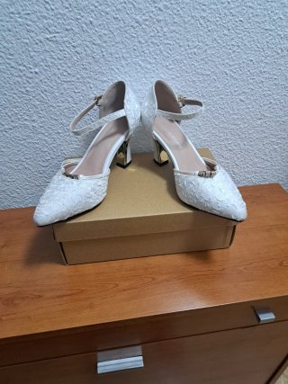 Zapatos de tacón blancos roto con pedrería .