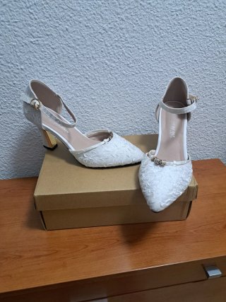 Zapatos de tacón blancos roto con pedrería .