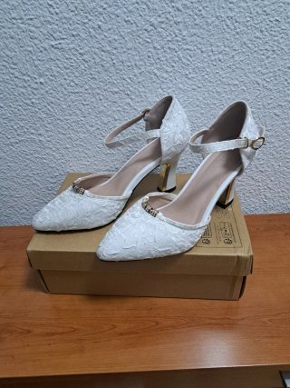 Zapatos de tacón blancos roto con pedrería .
