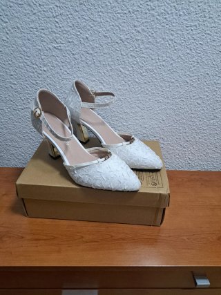Zapatos de tacón blancos roto con pedrería .