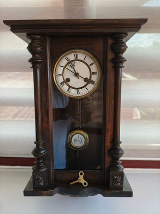 Reloj de pared antiguo de madera con sonería.