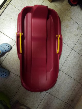 Trineo rojo con asas amarillas