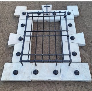 Ventana de piedra y forja con cruz