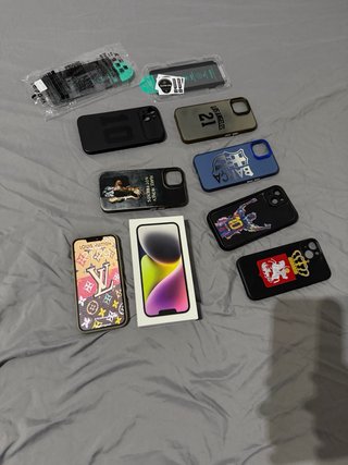 iPhone 14 con su caja, cargador original, fundas