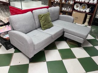 Sofá modular gris con cojín verde
