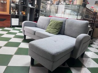 Sofá modular gris con cojín verde
