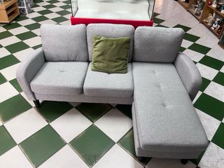 Sofá modular gris con cojín verde