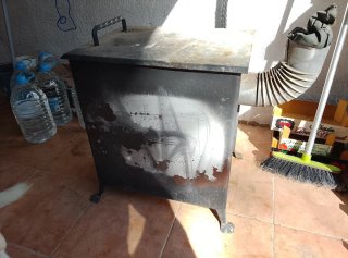 Chimenea con horno de leña fabricado en hierro.