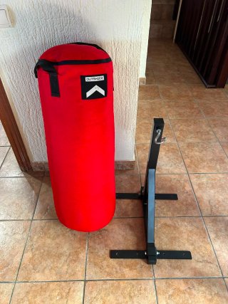 Saco de boxeo rojo con soporte de pared.