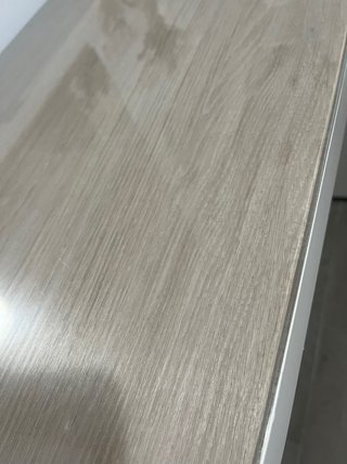 Tocador blanco con superficie de cristal.