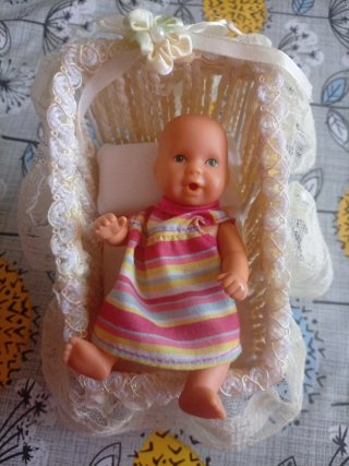 Muñeco bebé con cuna