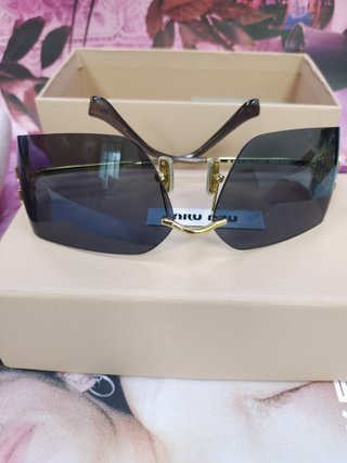 Gafas de sol Miu Miu negras y doradas