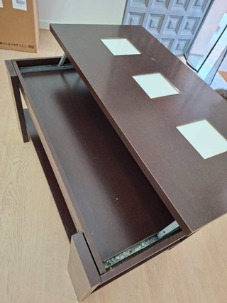 Mesa de centro oscura con estante y armario.