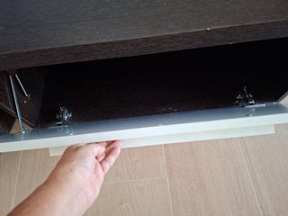 Mesa de centro oscura con estante y armario.