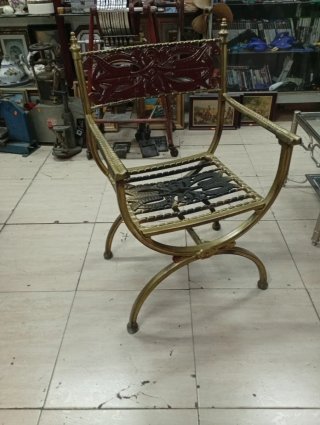Silla de aluminio dorada con detalles rojos