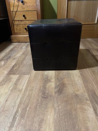 Perchero de hierro negro y puf cuero marron