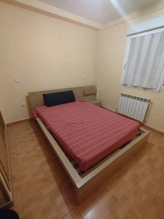Cama de madera con cabecero y mesita