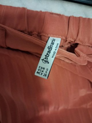 Falda plisada naranja botones por delante.