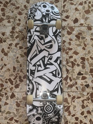 Monopatín con diseño graffiti y calaveras