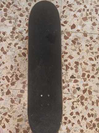 Monopatín con diseño graffiti y calaveras