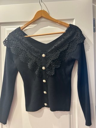Jersey negro con encaje y botones nacarados