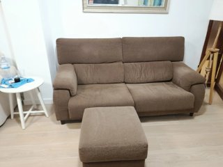 Sofá de tela marrón con reposapiés