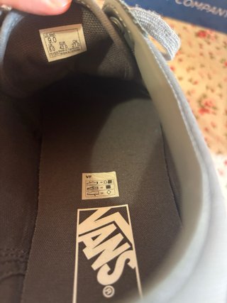 Zapatillas Vans grises y blancas.