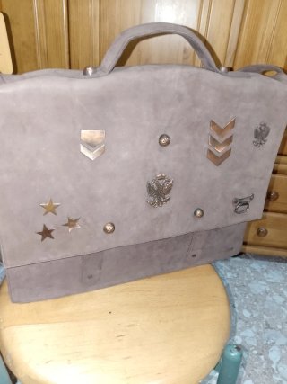Bolso de piel marrón con adornos dorados