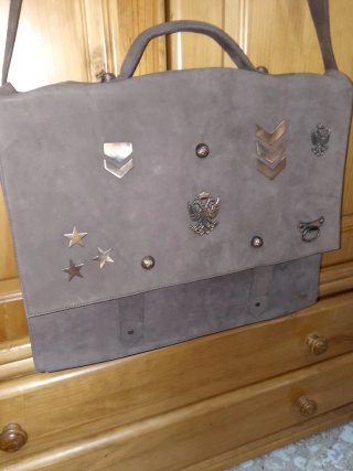 Bolso de piel marrón con adornos dorados