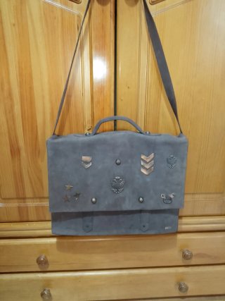 Bolso de piel marrón con adornos dorados