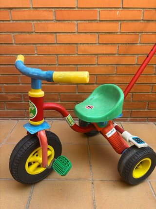 Triciclo infantil rojo, verde y amarillo