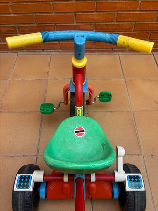Triciclo infantil rojo, verde y amarillo