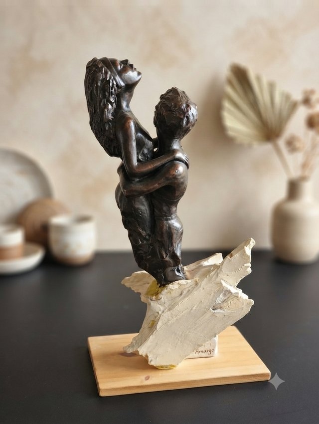 Coppia di sculture che abbracciano la base in legno