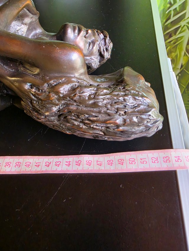 Coppia di sculture che abbracciano la base in legno