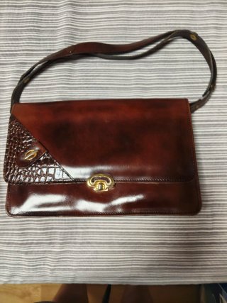 Bolso de piel marrón con detalles dorados