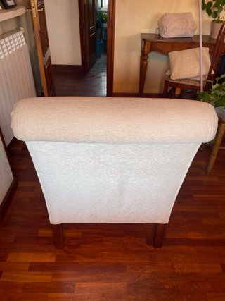Sillón de tela beige con patas de madera