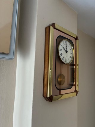 Reloj de pared con péndulo dorado