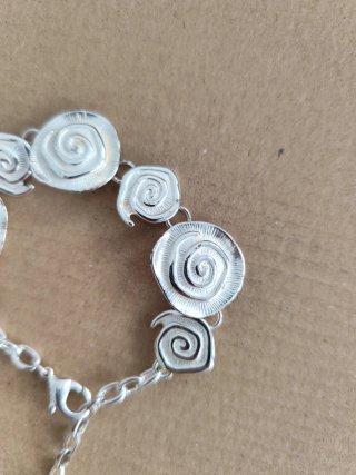 Pulsera plateada con diseño de rosas