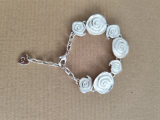 Pulsera plateada con diseño de rosas